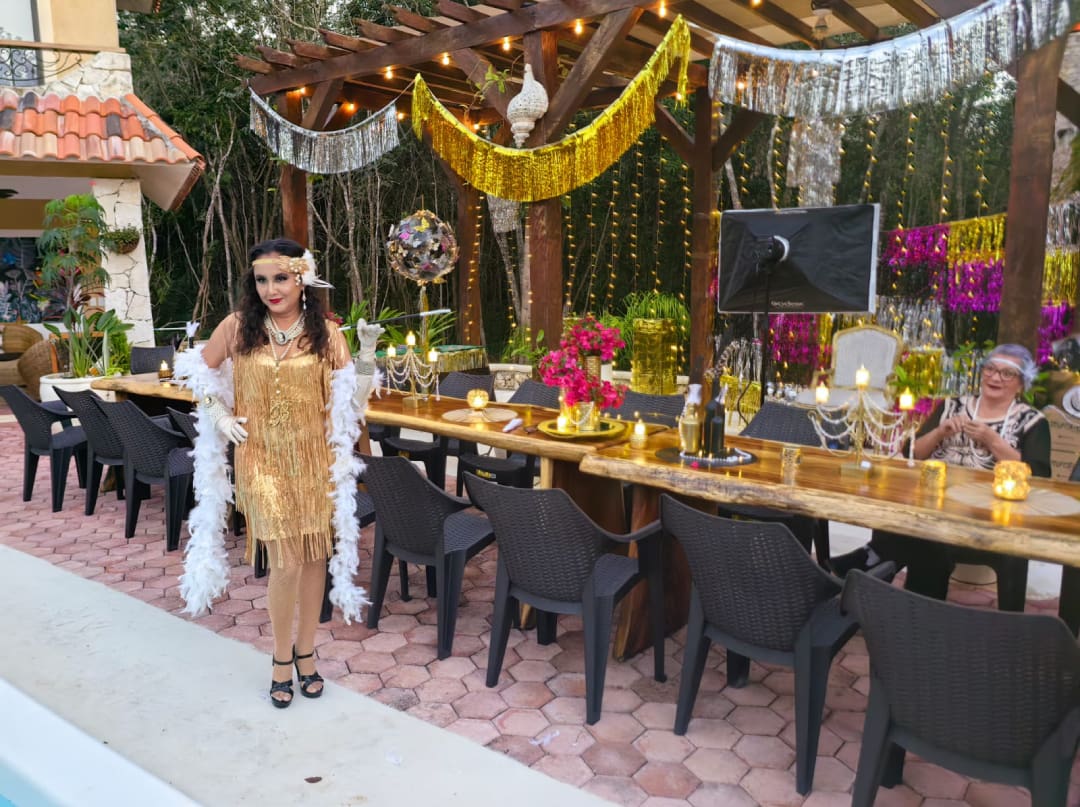 A woman standing in front of a long table with chairs.