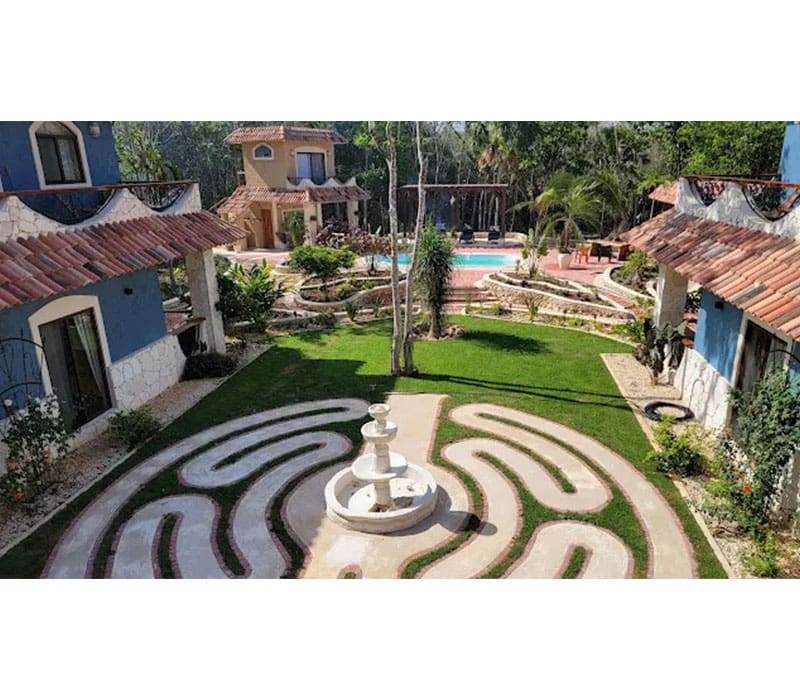 A view of a garden with a fountain and a pool.