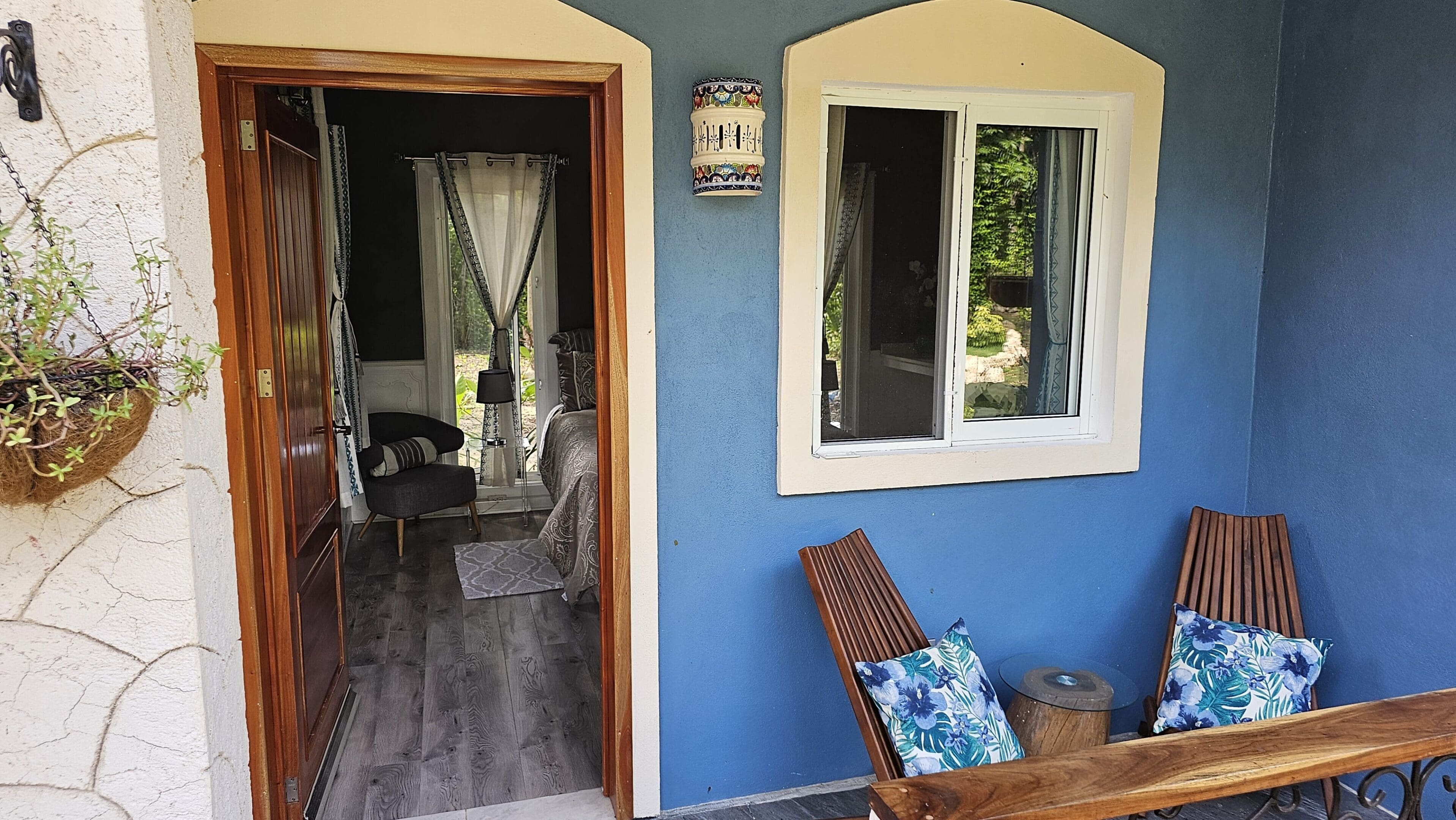 A blue wall with two windows and a chair