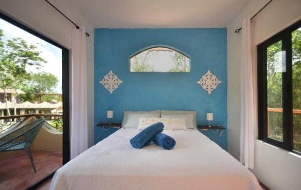 A bed room with a blue wall and white sheets