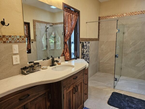 A bathroom with two sinks and a walk in shower.