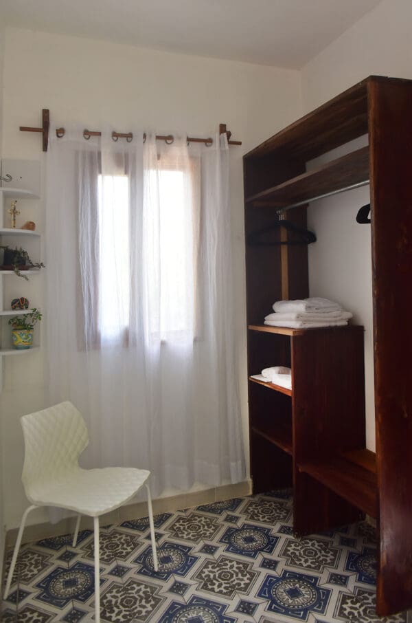 A white chair in front of a window.