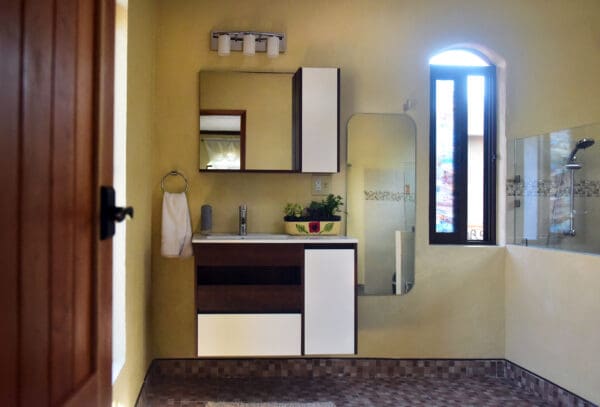 A bathroom with a sink, mirror and cabinet.