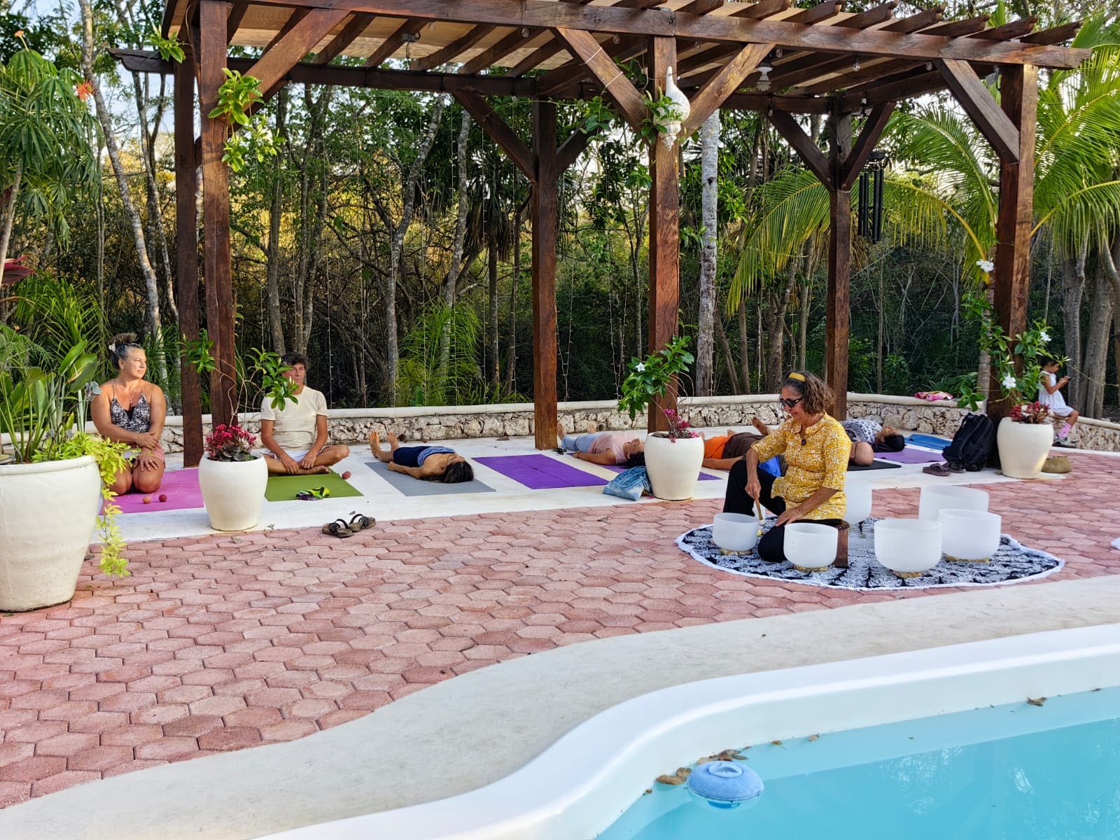 A group of people sitting around by the pool